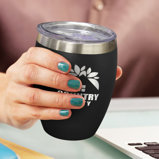 A drink bottle with a black exterior and stainless steel rim, featuring a logo. It is held in a hand with teal nail polish.