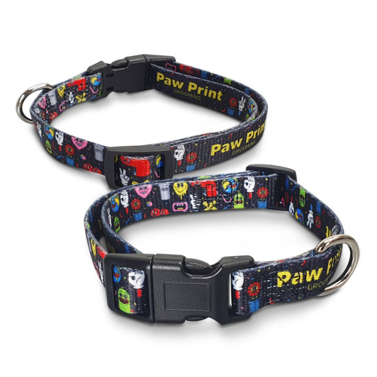 A dog collar featuring a colourful paw print design, with a plastic buckle and a metal ring for attachments.