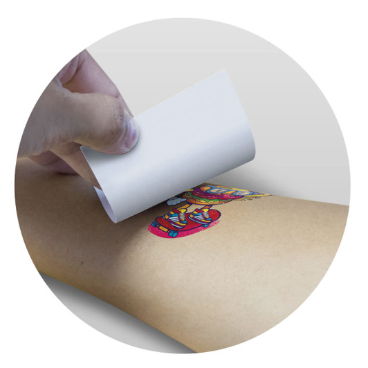 A hand applying a temporary tattoo foil to an arm, featuring a colorful design. The tattoo measures 51mm x 51mm.