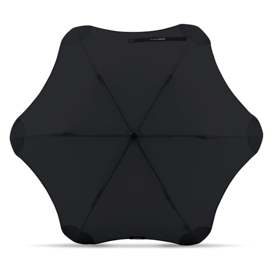 A black BLUNT Metro UV umbrella with a unique sculpted shape and a central button mechanism. It features branding.