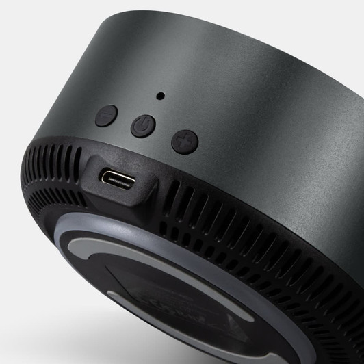 A wireless charging speaker in black with control buttons and a USB-C port. It features a sleek, circular design.
