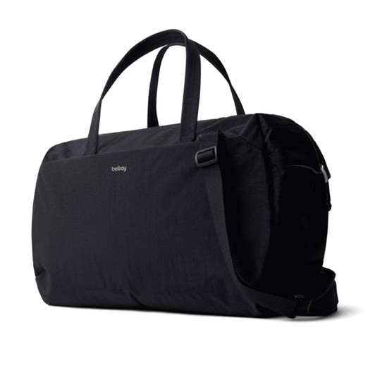 A black duffel bag with two handles and a shoulder strap, featuring a logo.