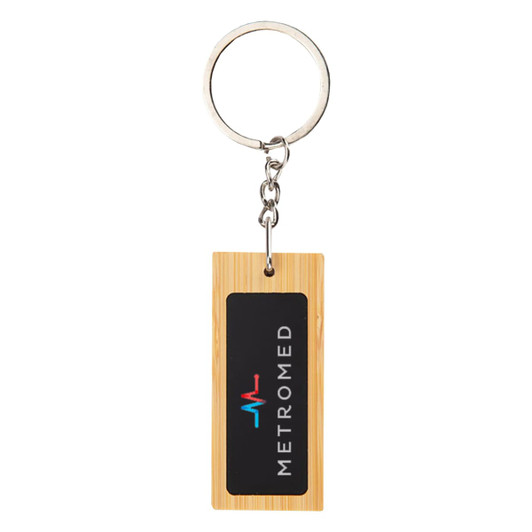 A rectangular bamboo keyring featuring a black insert with a logo. The keyring has a silver metal ring attachment.