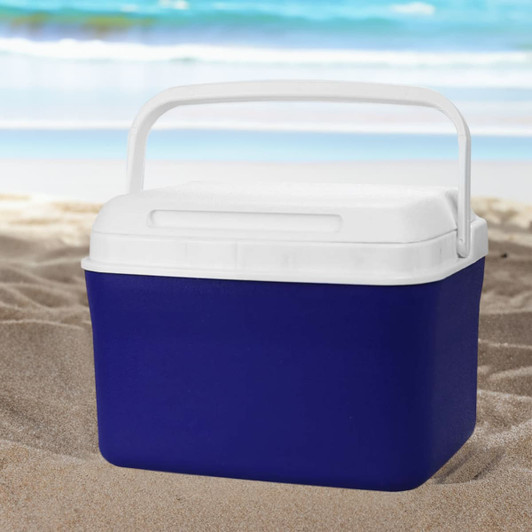 A cooler box in navy blue with a white lid and handle, set against a beach background.