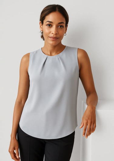 A sleeveless blouse in light grey with pleat detail, worn by a model standing against a neutral background.