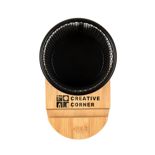 A black pen tidy phone stand with a bamboo base, featuring a logo on the front.