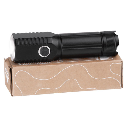 A black LED torch resting on a light brown cardboard box, featuring a textured grip and a push button.