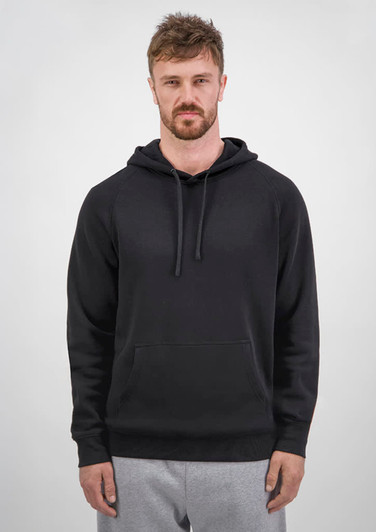 A man wearing a black hoodie with a drawstring and front pocket, paired with grey sweatpants.