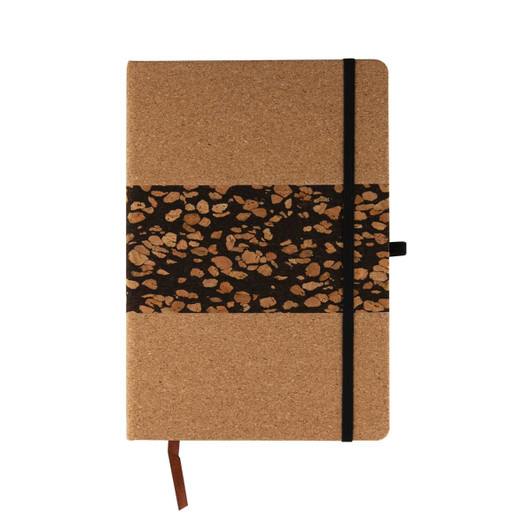 A notebook with a cork cover and a decorative band featuring coffee grounds patterns, secured with a black elastic.