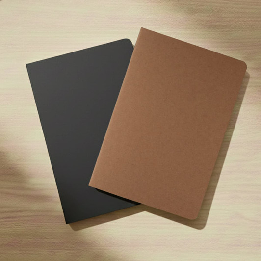 A set of two notebooks, one in black and the other in brown, placed on a wooden surface.