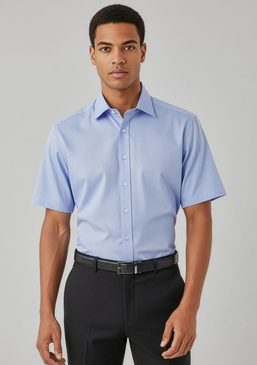 A light blue short sleeve button-up shirt, featuring a collar and a logo, worn with black trousers.