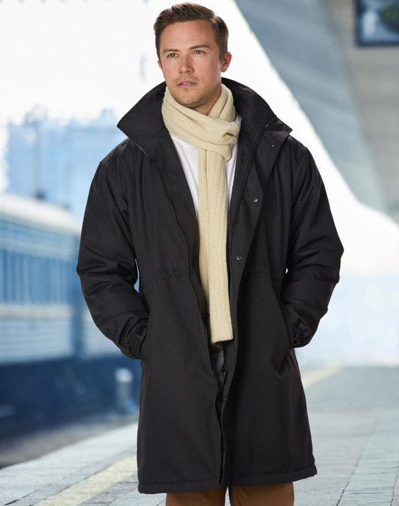 A man wearing a long black stadium jacket with a high collar, paired with a cream scarf.