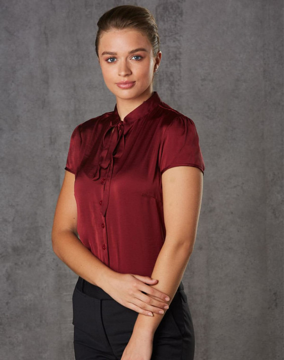 A maroon women's tie neck blouse with short sleeves, featuring a button-down front and a sleek, polished design.