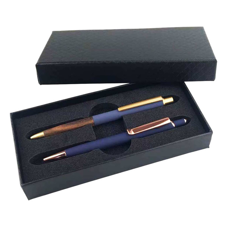 A gift set featuring two metal pens in a black box, one with a wooden finish and gold accents, and one in navy blue with rose gold accents.