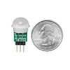 Mini PIR motion sensor shown next to a US quarter for size comparison.