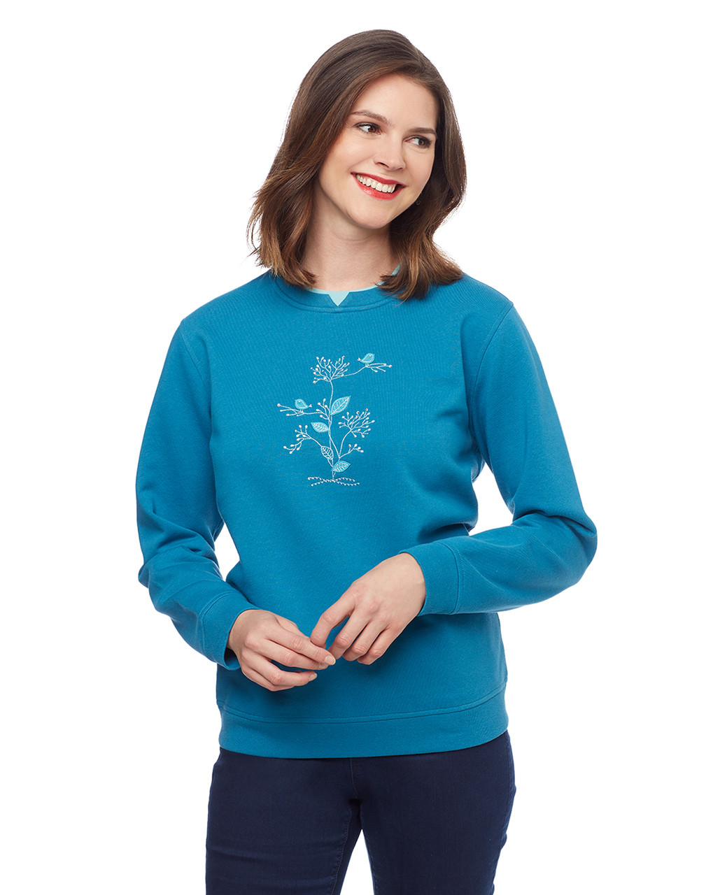 Woman in teal pullover sweater with blue birds applique