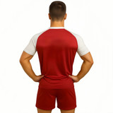 A red and white V-neck raglan sport tee shirt displayed on a model from the back, wearing matching shorts.
