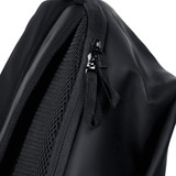 A close-up of a black backpack featuring a zip and mesh detailing. The material appears durable and water-resistant.