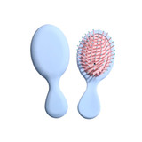 A light blue mini paddle brush with a pink bristle head, featuring a logo on the handle.