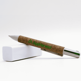 A cork pen with a silver clip, resting on a white block, featuring branding on the cork barrel.