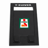 A black foldable phone stand featuring a logo on the front. The design is sleek and minimalist.