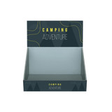 A corrugated cardboard counter display in dark green with a mountain design and no products visible inside.