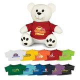 A white plush bear wearing a red t-shirt, surrounded by various coloured t-shirts in different styles and designs.