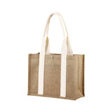A jute tote bag in natural brown with cream handles and a metal snap closure. It features a branding logo.