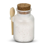A frosted glass jar filled with white bath salts, topped with a cork lid and a small wooden spoon.