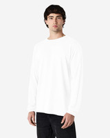A model wearing a white long sleeve T-shirt with a simple design, paired with black jeans.
