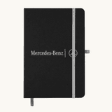 A black A5 notebook with an elastic closure and a logo on the front, featuring a grey band and bookmark.