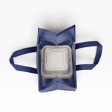 A navy insulated reusable bag with two handles, containing a square white food container inside. It has a logo on the exterior.