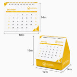 A yellow desk calendar with an organiser, featuring a spiral top and a triangular base, displaying the month of December.