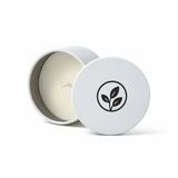 A mini tin candle with a white exterior and a leaf logo, featuring a clean white wax interior.
