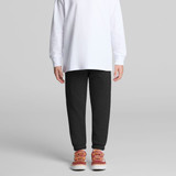 Track pants in dark grey, paired with a long-sleeve white top and red-orange shoes, featuring a logo.