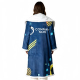 A plush blue blanket with a white fuzzy collar, featuring abstract patterns and a logo.