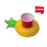 An inflatable cup holder shaped like a yellow pineapple, featuring a green leafy top and a red cup.