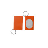 An orange pet training clicker with a keyring attachment and an oval mirror on one side.