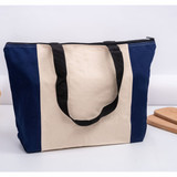A tote bag featuring a navy blue and cream design, with black handles and a zip closure. A tote bag featuring a navy blue and cream design, with black handles and a zip closure.