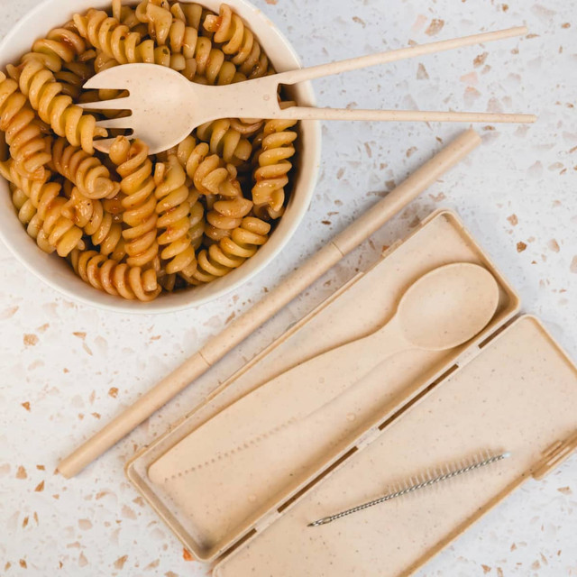 A Ramen Cutlery Set featuring bamboo fork, spoon, chopsticks, and a cleaning brush, presented with a bowl of fusilli pasta.