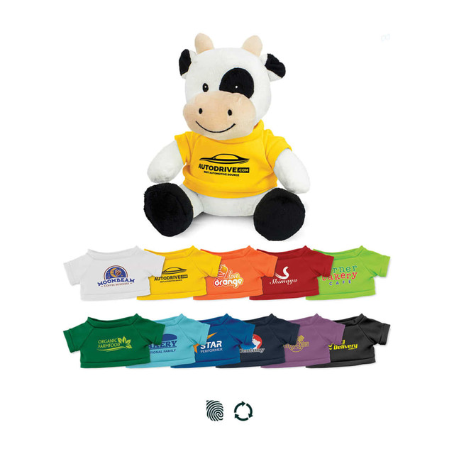 A cow plush toy wearing a yellow shirt, surrounded by various t-shirts in different colours and designs.