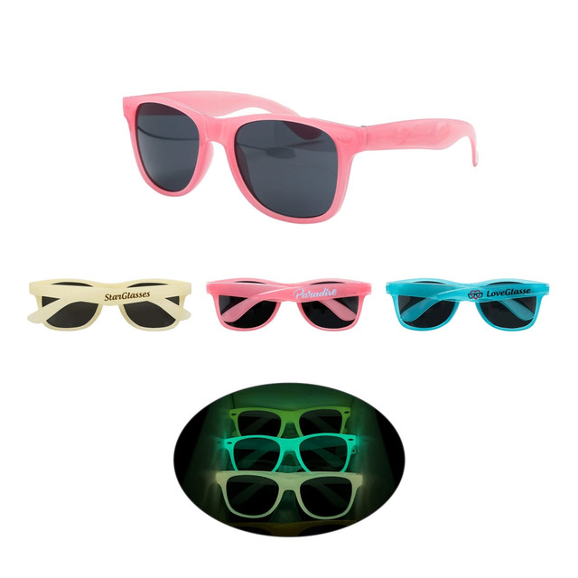 A collection of glow-in-the-dark sunglasses in pink, blue, and cream, with various styles and a logo visible on some.