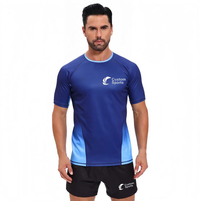 A man wearing a blue and light blue 100% polyester crew neck raglan tee shirt with a logo on the front.