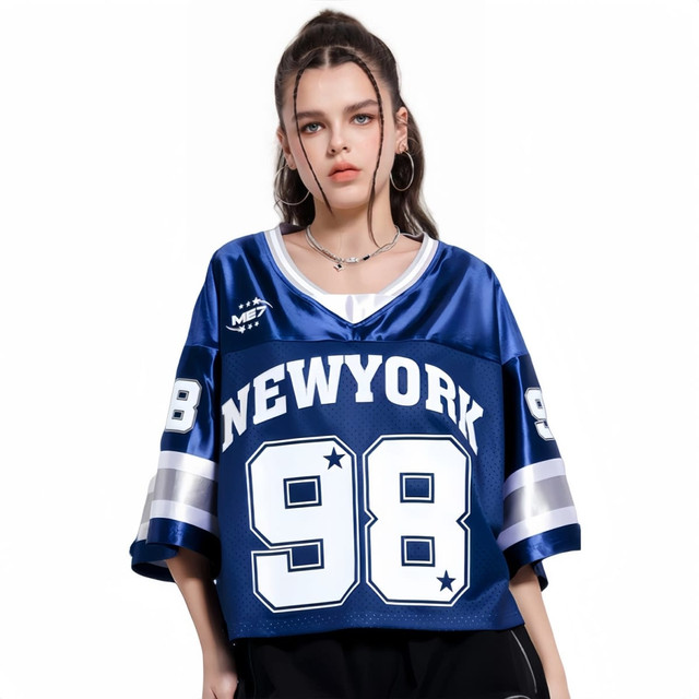 A blue unisex crop jersey featuring “NEWYORK” and “98” printed prominently, with contrasting sleeves and a logo.