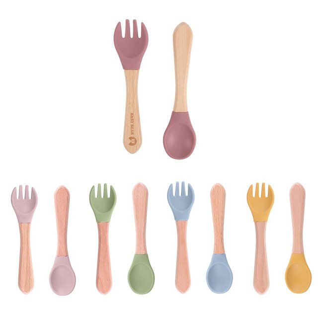 Ergonomic silicone cutlery set for kids featuring pastel colours and wooden handles, with a logo present.
