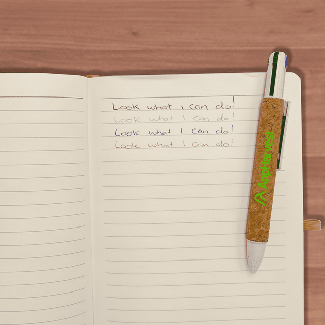 A cork pen with a green clip resting on an open lined notebook with handwritten notes.