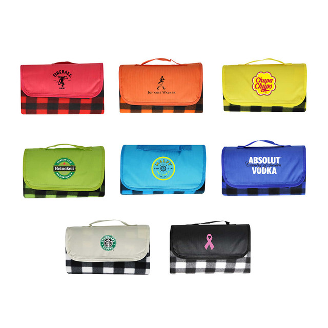 A variety of picnic blankets in bright colours, featuring different logos and a black and white checkered design.