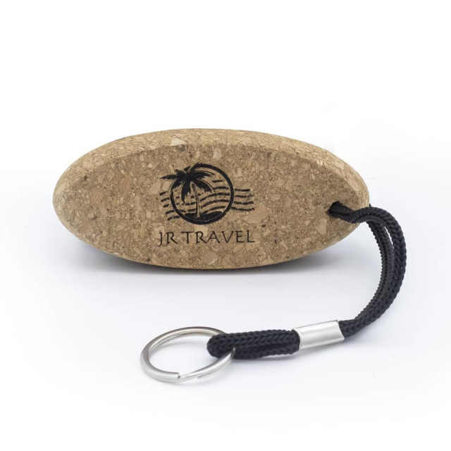 A cork floating keychain with a black strap and a silver keyring, featuring a logo on its surface.
