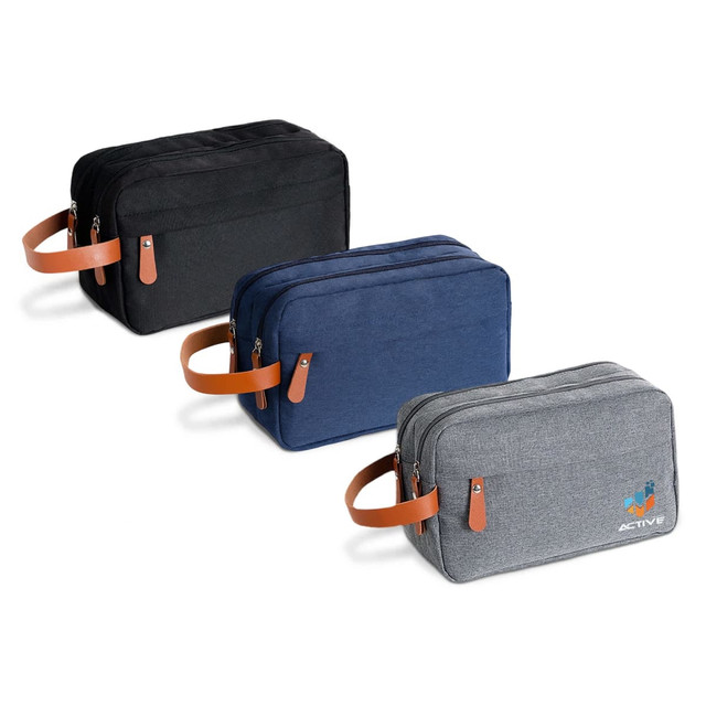 Three toiletry bags in black, navy, and grey, featuring leather handles and a logo on one bag.