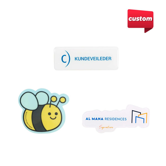 Custom acrylic name badges in various shapes, featuring a bee design and a logo, predominantly in white and colour.